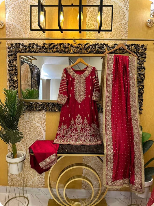 Red traditional outfit with gold details hanging on a decorative mirror in a room.